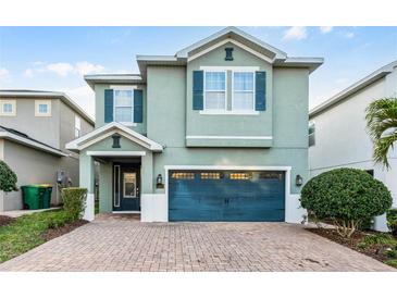 Charming two-story home featuring a brick driveway, teal shutters and a matching two-car garage door at 350 Pendant Ct, Kissimmee, FL 34747
