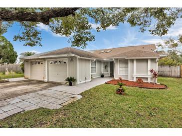 Charming single-story home with attached garages, complemented by a well-maintained lawn and tasteful landscaping at 7933 Merrimac Cove Dr, Orlando, FL 32822