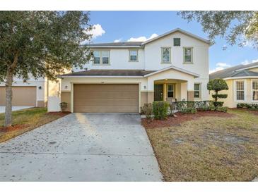 Two-story home with a two-car garage and a well-maintained lawn at 947 Emerald Green Ct, Kissimmee, FL 34746
