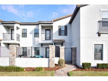 Two-story townhome with a gated front patio and well-manicured lawn at 113 Kenny Blvd, Haines City, FL 33844