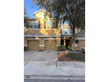 Inviting townhome showcasing a neatly manicured front yard with a two-car garage and charming architectural details at 14257 Desert Haven St # Ge, Windermere, FL 34786