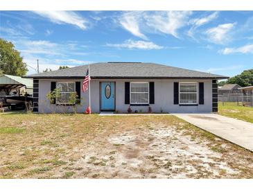 Charming single-story home with a bright blue front door and an American flag at 152 Harrison St, Lake Wales, FL 33859