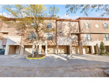 Charming townhome with a stucco exterior, stone accents, and attached garages at 6109 Metrowest Blvd # 105, Orlando, FL 32835