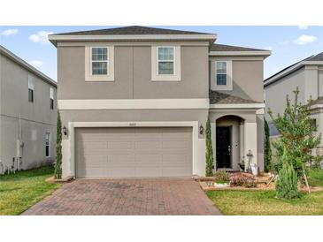 Charming two-story home with neutral paint, a two car garage and a well maintained, landscaped yard at 1669 Swan Swim Dr, Davenport, FL 33837