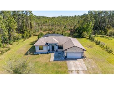 An aerial view of a charming single-story home with a two-car garage, a screened-in pool, and a large landscaped yard at 1741 Eldorado Ct, St Cloud, FL 34771