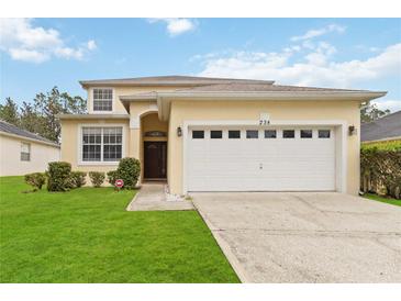 Charming two-story home featuring a well-manicured lawn and an attached two-car garage at 238 N Hampton Dr, Davenport, FL 33897