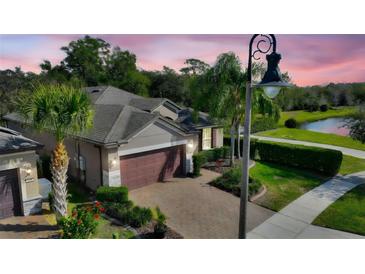 Charming single-Gathering home features a paver driveway, two car garage and tropical landscaping at 246 Tomelloso Way, Davenport, FL 33837