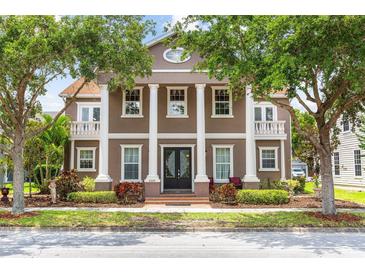 Stately two-story home featuring impressive white pillars, balconies, and mature trees at 3329 Schoolhouse Rd, Harmony, FL 34773