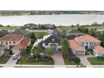 Stunning aerial view of a luxurious home with solar panels and a picturesque lake backdrop at 4959 Tennessee Lake Dr, Auburndale, FL 33823