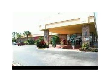 Inviting exterior view of the building's entrance, featuring well-maintained landscaping and ample parking at 7900 S Orange Blossom Trl # 2075, Orlando, FL 32809