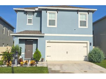 Charming two-story home featuring a well-manicured front yard and a two car garage at 1292 Cascades Ave, Davenport, FL 33837