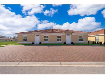 Charming single-story duplex with red brick driveway and tile roof under a partly cloudy blue sky at 1623 Cumin Dr, Kissimmee, FL 34759