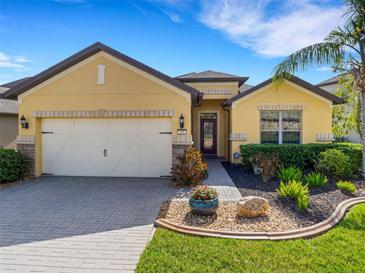 Charming home featuring a well-manicured lawn, a two-car garage, and tasteful landscaping at 208 Almeria Way, Davenport, FL 33837