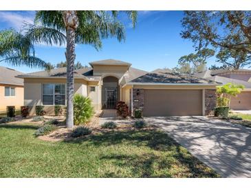 Charming single-story home with a well-manicured lawn, brick driveway, and a 2-car garage at 280 Del Sol Ave, Davenport, FL 33837