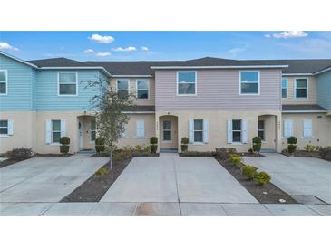 Charming townhomes feature colorful exteriors, well-manicured landscaping, and private driveways at 4846 Coral Castle Dr, Kissimmee, FL 34746