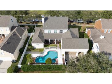 An aerial view of a spacious property featuring a sparkling blue pool and attached garage at 614 Golfpark Dr, Kissimmee, FL 34747