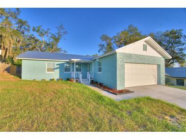 Charming home features a well-maintained lawn, a one car garage, and a light blue exterior at 713 Greenleaf Ln, Lake Wales, FL 33853