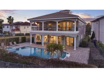 Stunning two-story home with balcony, pool, and a beautiful outdoor entertaining space at 7471 Gathering Loop, Reunion, FL 34747