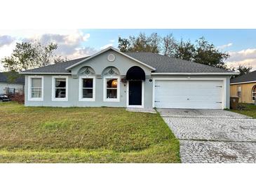 Charming single-story home with a grey exterior, complemented by a well-manicured front yard and driveway at 856 Jarnac Dr, Kissimmee, FL 34759