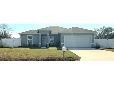 Charming single-story home with a well-manicured lawn, two car garage, and inviting entrance at 125 Inconnu Ct, Poinciana, FL 34759