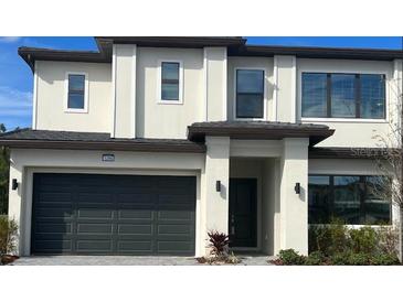 Two-story home featuring a neutral color scheme, multiple windows, and an attached two-car garage at 1298 Butterfly, Davenport, FL 33837