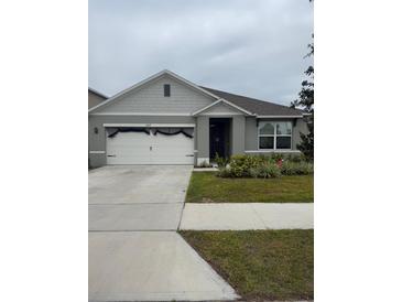 Charming single-story home with a well-manicured lawn and attached two-car garage, perfect for suburban living at 1827 Silverbell Loop, Haines City, FL 33844