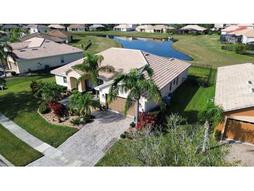 Aerial view of a landscaped property with a tile roof and a view of a pond in the backyard at 4018 Navigator Way, Kissimmee, FL 34746