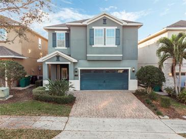 Charming two-story home with a well-manicured front yard, a brick driveway, and a two-car garage at 430 Novi Path, Kissimmee, FL 34747