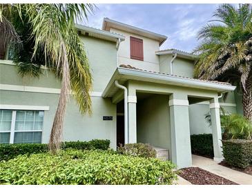 Inviting two-story townhouse with lush landscaping and a covered front entrance at 4875 Clock Tower Dr, Kissimmee, FL 34746