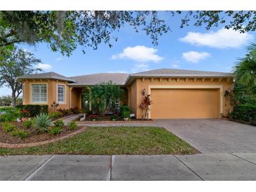 Charming single-story home featuring a well-manicured lawn and a two-car garage, with colorful landscaping at 651 Glendora Rd, Kissimmee, FL 34759