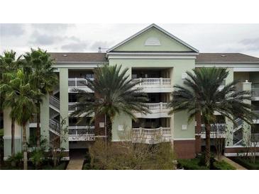 Condo exterior featuring balconies, stairways, and palm trees at 7660 Whisper Way # 104, Reunion, FL 34747