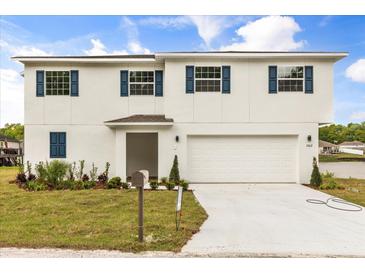 Two-story home with a white exterior, blue shutters, and well-maintained landscaping at 1062 Hidden Dr, Lakeland, FL 33809