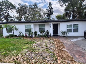 Charming single-story home featuring a well-manicured lawn and a brick walkway leading to the front door at 5100 Londonderry Blvd, Orlando, FL 32808