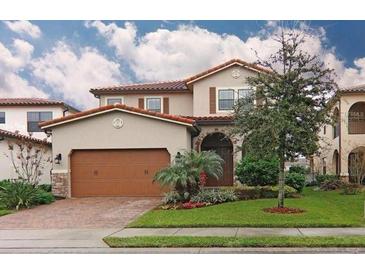 Charming two-story home featuring a tile roof, arched entry, and a well-manicured lawn at 10467 Henbury St, Orlando, FL 32832