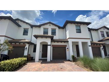 Charming townhome featuring a well-maintained front yard and a brick driveway at 1258 Royal St George Blvd, Davenport, FL 33896