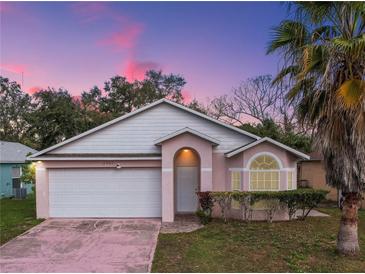 Charming single-story home featuring a well-manicured lawn and a two-car garage at 4941 Luna Negra Dr, Orlando, FL 32811