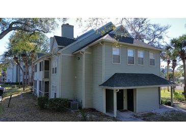 Inviting exterior view of a townhouse with a chimney and two front doors under a green roof at 6028 Westgate Dr # 104, Orlando, FL 32835