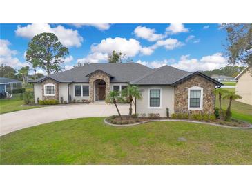 Charming stone accent home with well-manicured lawn and beautiful landscaping at 6301 Oak Shore Dr, St Cloud, FL 34771