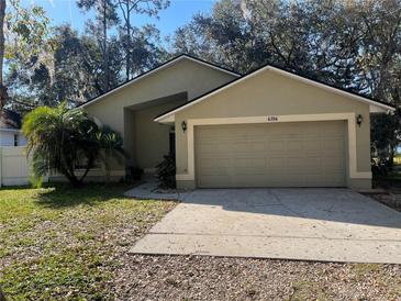 A charming one story home features an attached two-car garage and a well-maintained lawn at 6356 Bennett Ct, St Cloud, FL 34771