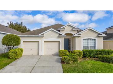 Charming single-story home features a two-car garage, neutral stucco facade, and well-manicured landscaping at 7735 Teascone Blvd, Kissimmee, FL 34747