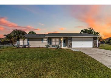 Charming single-story home features a stone-accented facade, a well-manicured lawn, and a spacious two-car garage at 1240 Beth Ln, St Cloud, FL 34772