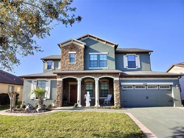 Two-story home featuring stone accents, covered porch with pillars and manicured lawn at 1820 Trophy Bass Way, Kissimmee, FL 34746