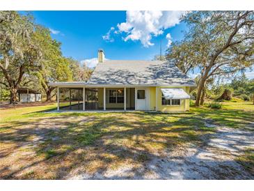 Charming cottage-style home with a screened porch and well-maintained lawn at 2921 Seminole Rd, St Cloud, FL 34772