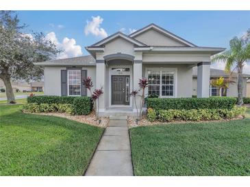 Charming single-story home with meticulously manicured front lawn, walkway, and mature landscaping at 3050 Grasmere View Pkwy, Kissimmee, FL 34746