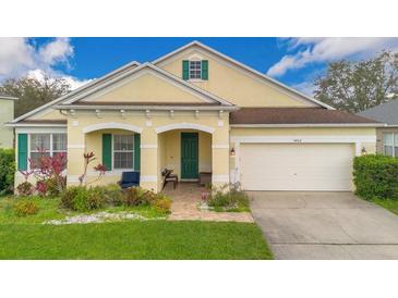 Charming single-story home with a well-manicured lawn, covered porch, and attached two-car garage at 3452 Goldeneye Ln, St Cloud, FL 34772