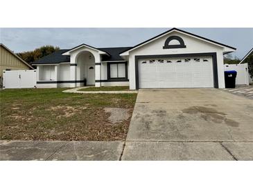 Charming single-story home with a well-maintained lawn, paved walkway, and attached two-car garage at 7860 Kensingham Ct, Orlando, FL 32835