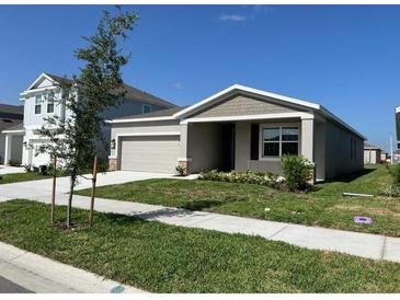 Charming single-story home with a well-manicured lawn and an attached two-car garage at 250 Brave Rd, Davenport, FL 33837