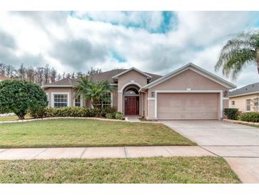 Charming single-story home with a well-manicured lawn, beautiful landscaping, and a two-car garage at 2512 Volta Cir, Kissimmee, FL 34746