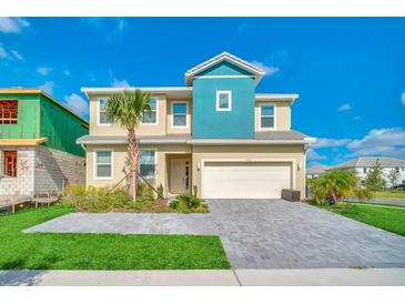 Inviting two-story home boasting blue accents, manicured landscaping, and a spacious two-car garage at 2536 Shanti Dr, Kissimmee, FL 34746