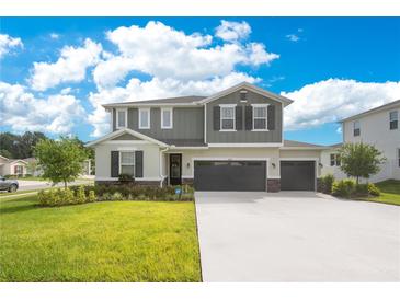 Beautiful two-story home featuring a well-manicured lawn and three-car garage at 31792 Broadwater Ave, Leesburg, FL 34748